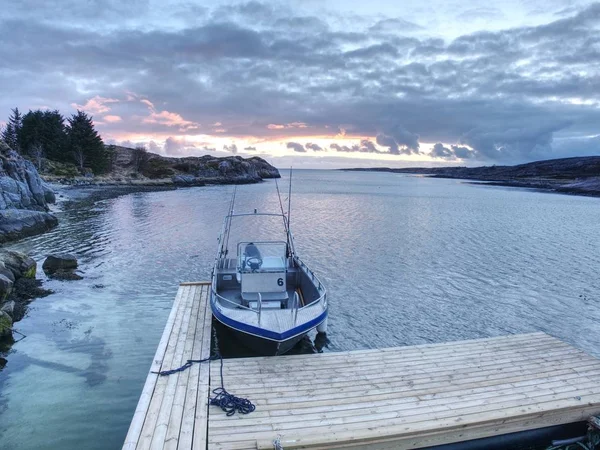 Vissersboot met hengels drijvende aan wal, kleurrijke zee avond. — Stockfoto