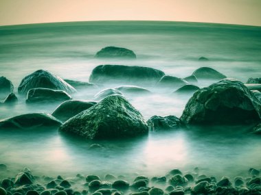 Yaz mevsim ve tatil görünümü. Denizde romantik sabah. Büyük kayalar 