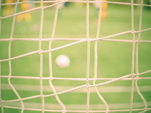 Detalhe em uma rede de futebol e bola esperando no relvado. Golo de futebol . — Fotografia de Stock