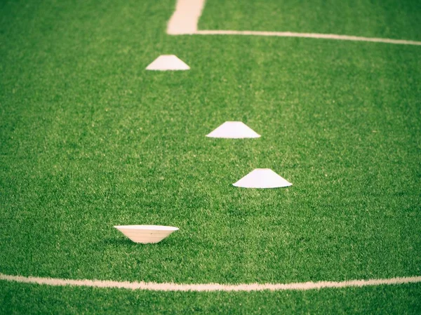 Stożek szkolenia dla piłki nożnej na zielonym polu. Sztuczna trawa zielony — Zdjęcie stockowe