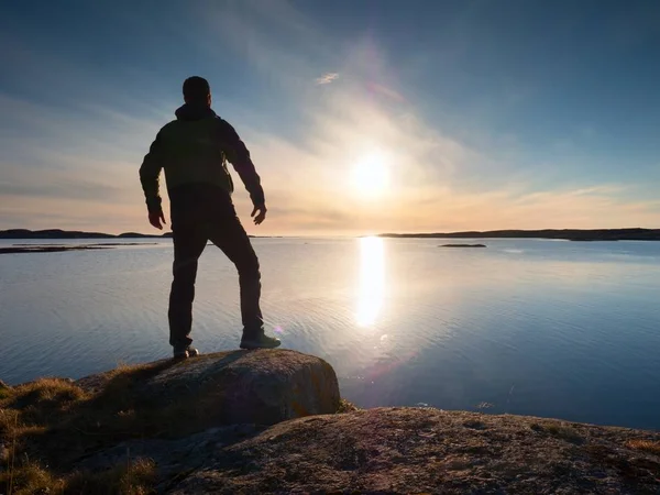 Joven viajero de pie sobre piedra y mirando al sol — Foto de Stock