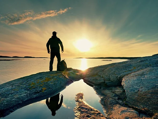 Silueta de hombre. Hermosa puesta de sol toque el mar en el horizonte, cielo azul claro. Senderista disfrutar del paisaje —  Fotos de Stock