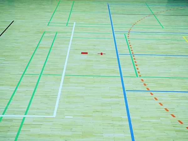 Green shadows of shining floor of sports hall with marking lines and few scratches