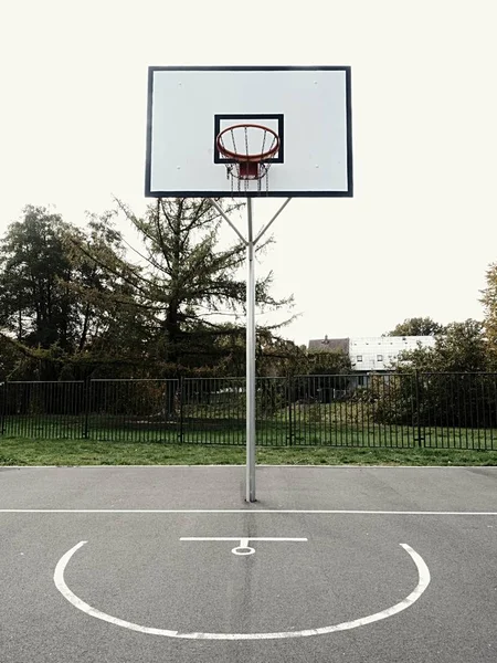 スカイラインと日没の都市バスケットボールのフープ — ストック写真