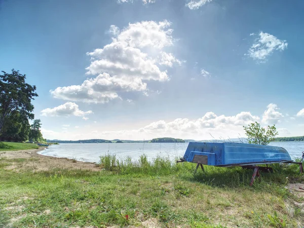 Altes Fischerruderboot kopfüber unter Baum am See gestapelt — Stockfoto