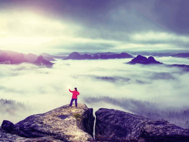 El feneri ile kayalık kıyıda duran kadının arka görüntüsü