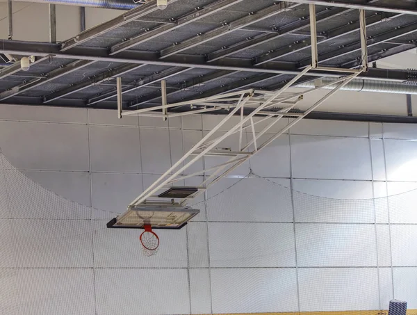 Canestro da basket pieghevole nella palestra del liceo. Reti di sicurezza — Foto Stock
