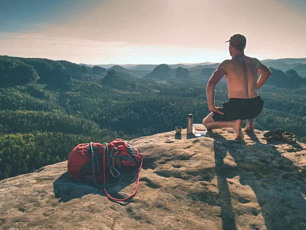Uomo nudo che fa un picnic. Toples climber sedersi e mangiare panino — Foto Stock