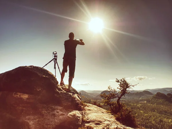 Viaggiatore con smartphone, soggiorno a treppiede con fotocamera in cima — Foto Stock