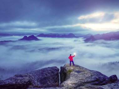 Karanlığın içine keskin ışık sinyalleri gönderen kadın.