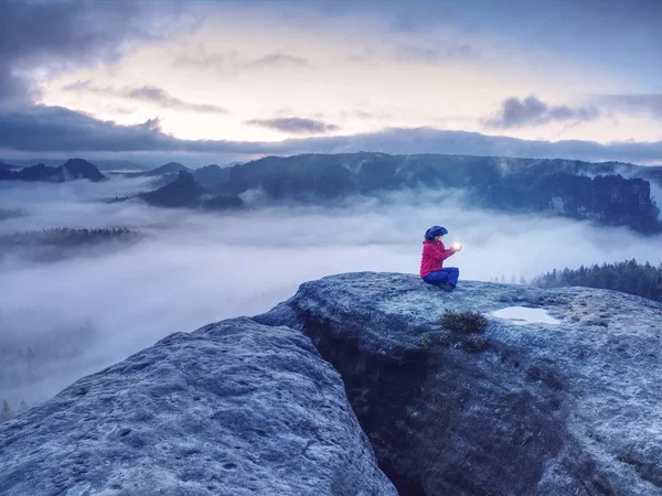 Ragazza da sola sedersi sulla cima della montagna piace nave in oceano nebbioso — Foto Stock