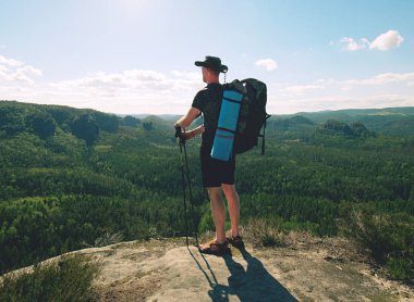 Sırt çantası ve sopaile Gezgin dağ zirvesinde görünüyor