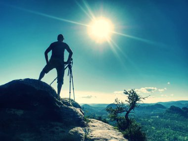 Kamera ve tripodla çalışan profesyonel fotoğrafçı.
