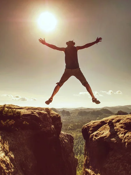 Melompat melawan Sun. Melompat ke tebing. Man on trail through rocks / J — Stok Foto