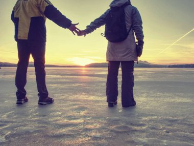 Donmuş bir gölde buz üzerinde yürüyen çift, erkek ve kadın