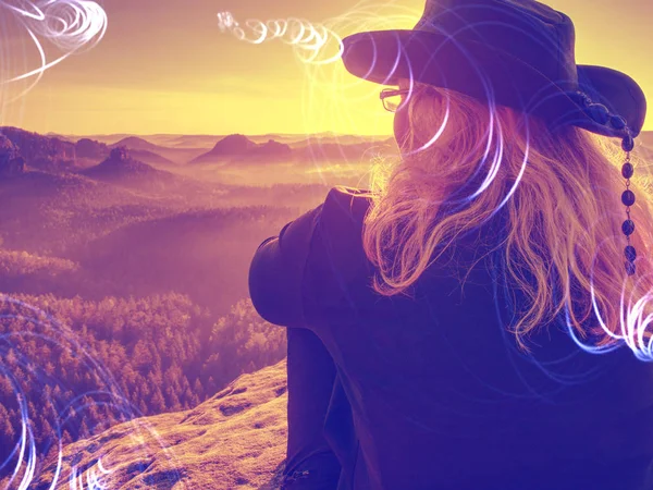 Женщина сидит на скале с видом на долину, горы — стоковое фото