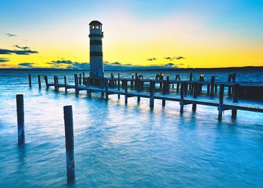 Deniz iskelesinin sonundaki deniz feneri. Soğuk rüzgarlı bir sabah 