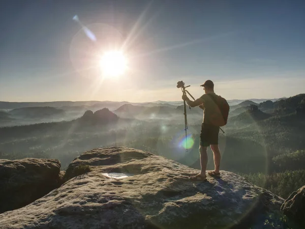 Fotografo uomo scattare foto sulla cima della montagna tramonto — Foto Stock