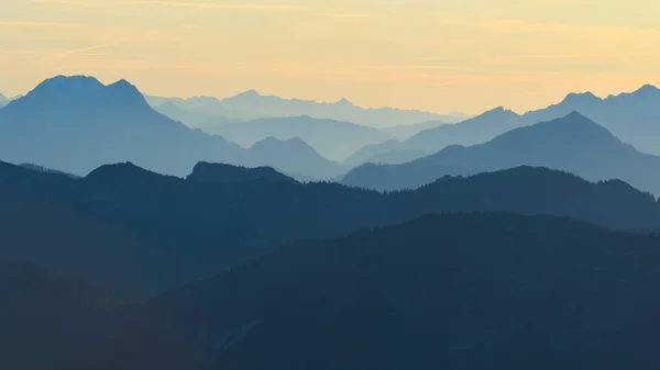 Alps mountain silhouettes and misty valleys. Misty awaking