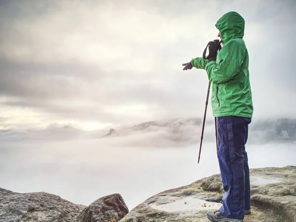 Backpacker stanna på våt sten. Dimmig soluppgång i steniga berg — Stockfoto