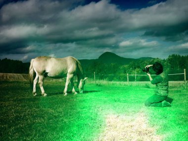 Bir atın yan yana fotoğrafını çekerken kadın sanatçı.