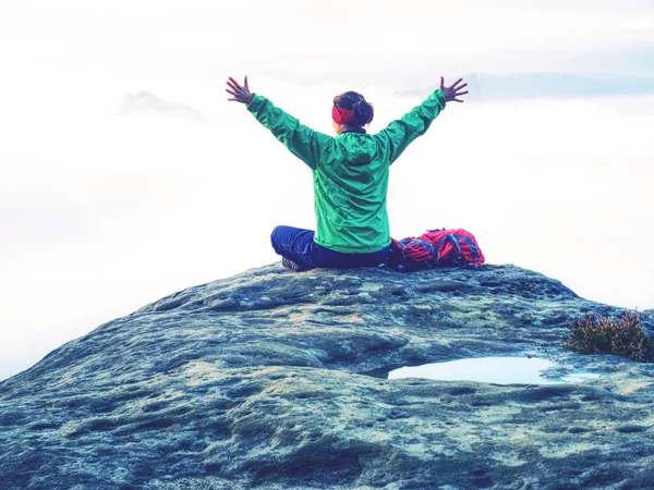 Girl on summit hands raised over clouds. Travel Lifestyle — Stock Photo, Image