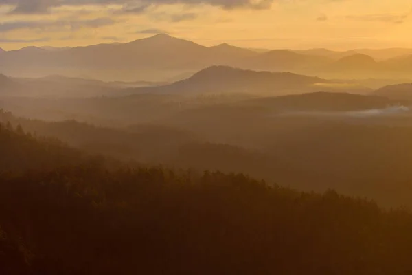 Oranje kleuren van zonsopgang in bergen, ochtendmist — Stockfoto