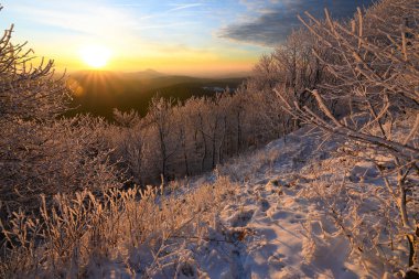 Mavi sisli tepelere karşı güneşin doğuşunun renkli sırtı