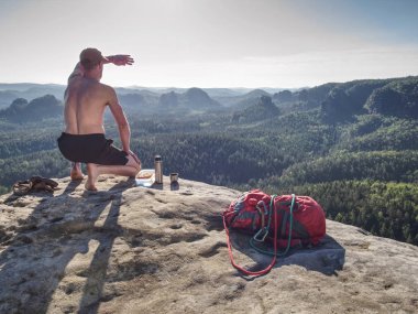 Yürüyüşçü yemek molası verir. Adam plastik kutu getiriyor. 