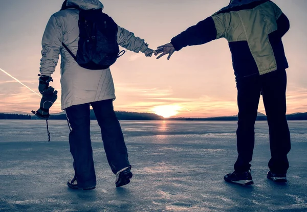 Casal se diverte durante o passeio de inverno no gelo do lago congelado — Fotografia de Stock