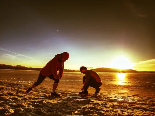 Atlético casal muscular alongamento na manhã inverno natureza — Fotografia de Stock