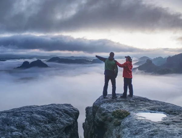 Verliebte spiegeln sich in Wasserauge auf Berggipfel über Nebel — Stockfoto