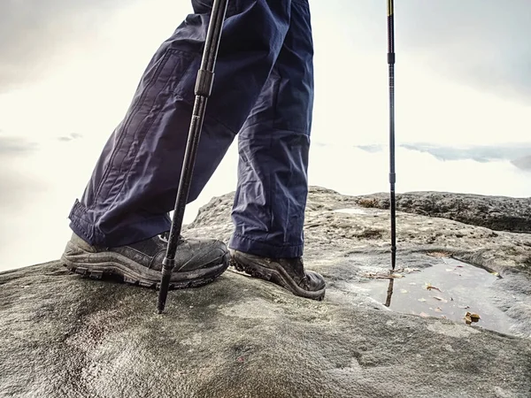 Hiker walks on Trail in warm trousers and waterproof boots