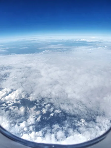 Nubes paisaje a través de ventana del avión — Foto de Stock