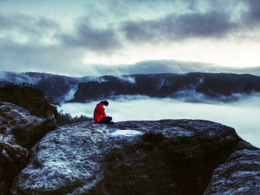 El feneri ile kayalık kıyıda duran kadının arka görüntüsü