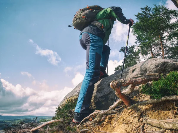 Man vandrare klättra använda trekking pinnar. Går försiktigt — Stockfoto