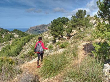 Yürüyüşçü kayalık patikada, dağ yürüyüşünde 