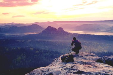Kameralı fotoğrafçı zirvede çalışıyor.