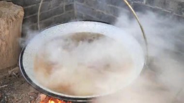Kızartma makinesinde et ve kemiklerle kaynayan sıcak suya yakın çekim. Erkek yemeği.