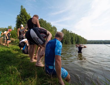 Sporcular gölette yarışa hazırlanıyorlar. Amatör SAMUEL XC triatlon Ravanec, Çek Cumhuriyeti. 23 Ağustos 2019