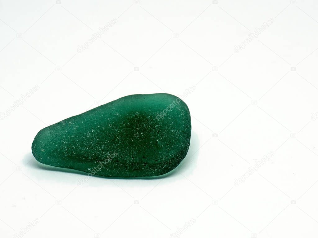 Big piece of bottle glass rounded and polished in sea. Popular glass stone as souvenir from beach.