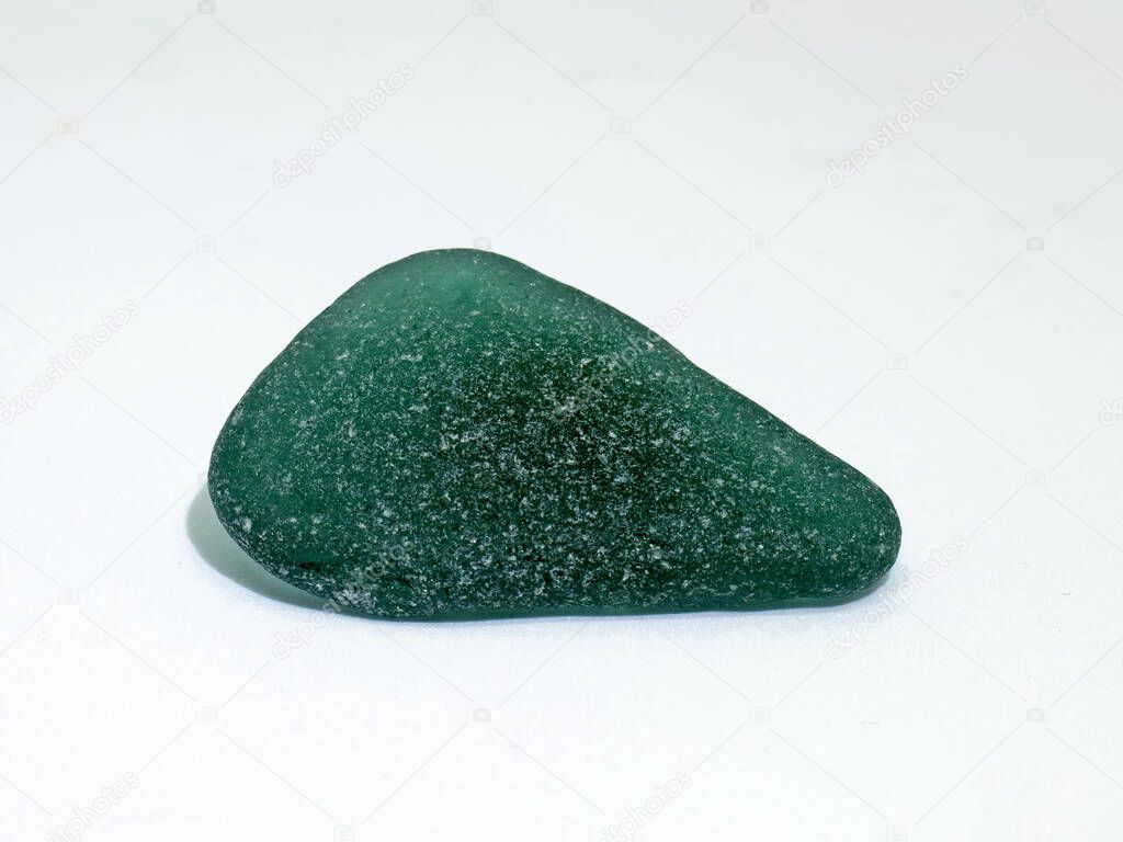 Structure of green bottle glass polished by sand and stones in waves of sea.