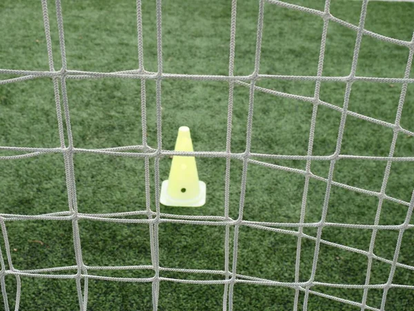 View through football gate net during a football mach. Goal keeper wait in front of gate line