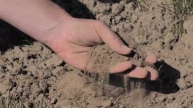 Elleri tarlasında kuru toprak gösteriyor. Kuru toprak çatlıyor. Çayırda kuru ve çatlak yerler. 