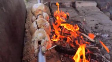 Döndürme makinesi ızgara tavuktur. Barbekü kutusunda dönen marine edilmiş iki tavuğun yan görüntüsü.