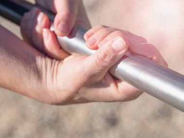 Eller bulanık arka planda yatay çubuğa tutunsun. Genç kız yükselmek için standartları aştı