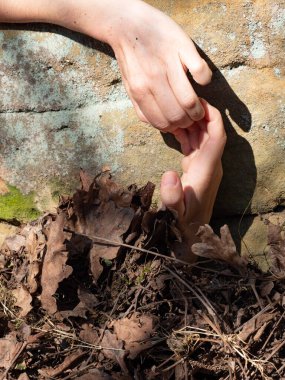 Mezarlıktaki çürümüş yapraklardan sarkan beyaz soğuk el.