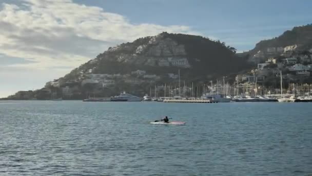 2020年1月28日 一名身穿救生衣的运动员在西班牙Illes Balears的Andratx港海岸附近划桨 — 图库视频影像