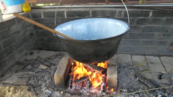 Chef is frying chopped onion in deep pod above open grill fire. Preparation of traditional goulash for family and friends party in the garden — Stock Footage Chef Frying Chopped Onion Deep Pod Open Grill Fire Preparation Stock Footage