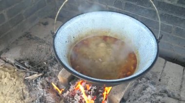 Kaynayan portakal suyu soslu ızgara gulaş çorbası ve sığır eti. Derin bir tencerede et ve otlarla kabarcık. Erkekler yemek yapıyor